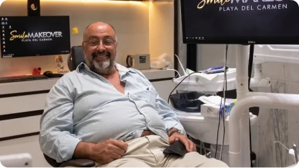 Happy male patient relaxing in a modern clinic chair after receiving a high-quality smile makeover with dental crowns.