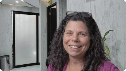 Smiling patient sharing her positive video review after a successful and affordable dental implants procedure.