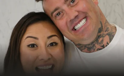 Close-up selfie of Dr. Martha Tziu and a male patient posing together, both showcasing bright, happy smiles after a successful dental visit.