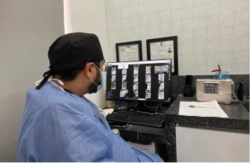 Dentist reviewing digital dental X-rays to diagnose and plan orthodontic treatment.