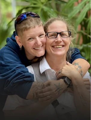 Happy couple patients smiling and embracing after completing cosmetic dental treatmen