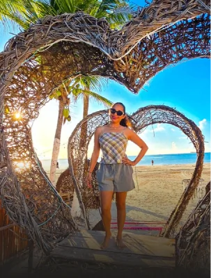 Happy dental tourism patient enjoying a relaxing beach vacation while traveling for an affordable smile makeover.