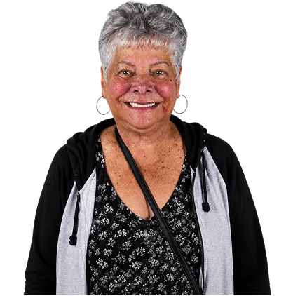 A happy senior woman dental patient with a confident smile, showcasing the results of snap-on dentures and dental implants