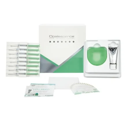 Opalescence take-home teeth whitening kit containing bleaching gel syringes, a custom tray case, toothpaste, and a shade guide for monitoring whitening progress