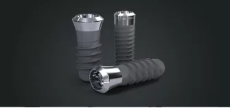 Multiple titanium dental implants displayed against a dark background, highlighting durability and strength.